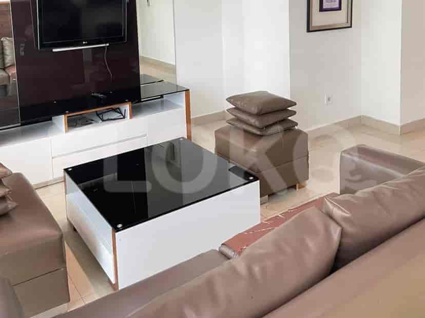 A modern living room featuring a brown leather sofa, a white and black coffee table, and a TV console.
