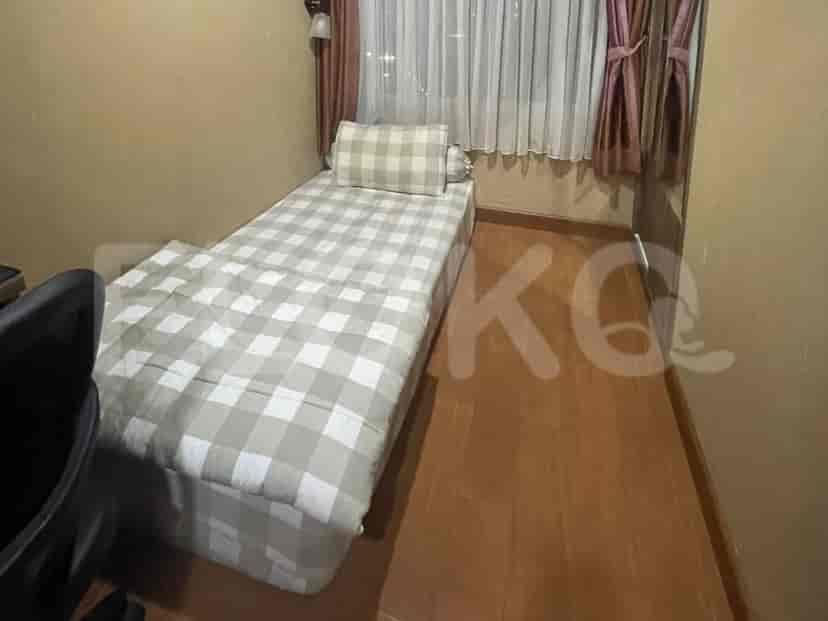 A small bedroom with a single bed and checkered bedding.