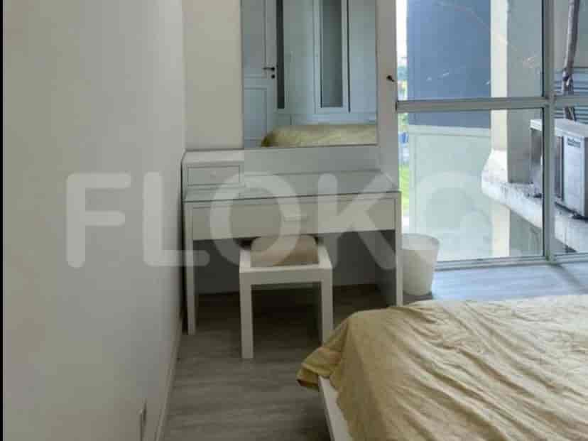 Bedroom with a vanity, large mirror, and a bed.