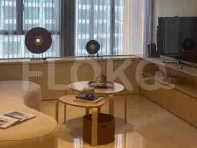 Living room with decorative objects, coffee tables, and large windows.