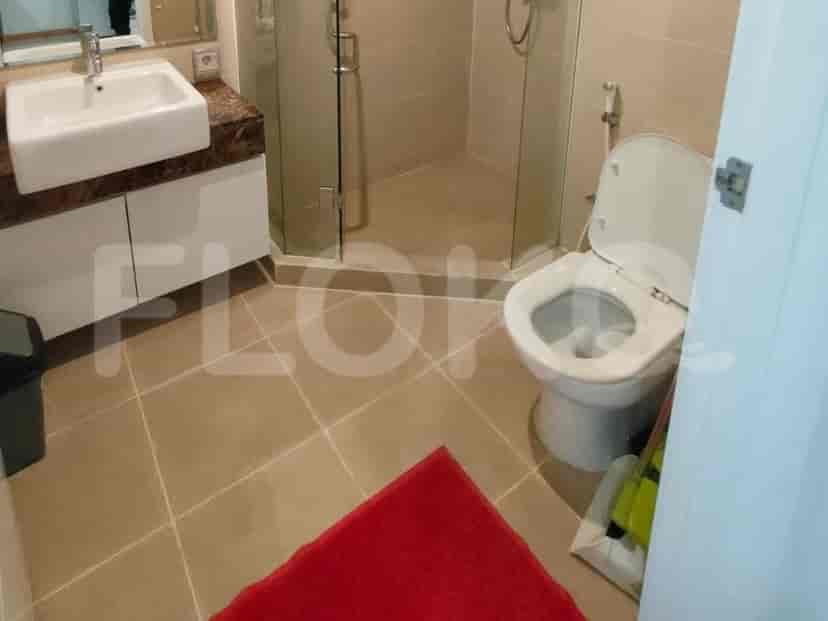 A bathroom with a white sink, toilet, and a glass-enclosed shower.