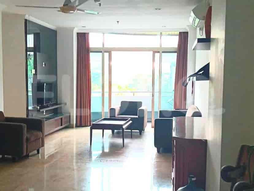 Sebuah ruang tamu dengan sofa, meja kopi, dan jendela besar dengan gorden.