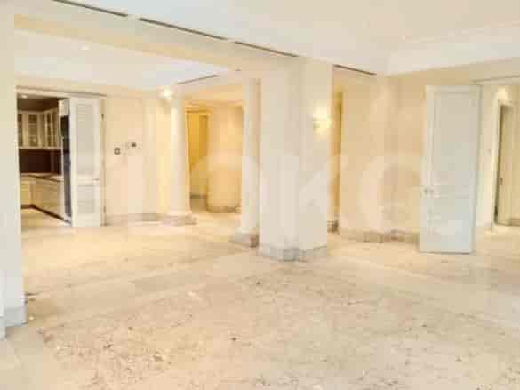 A spacious living room with marble floors, columns, and white walls.