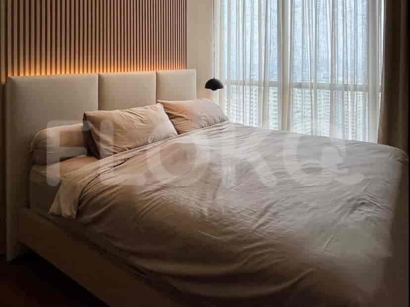 A cozy bedroom with a king-size bed, upholstered headboard, and a large window with sheer curtains.