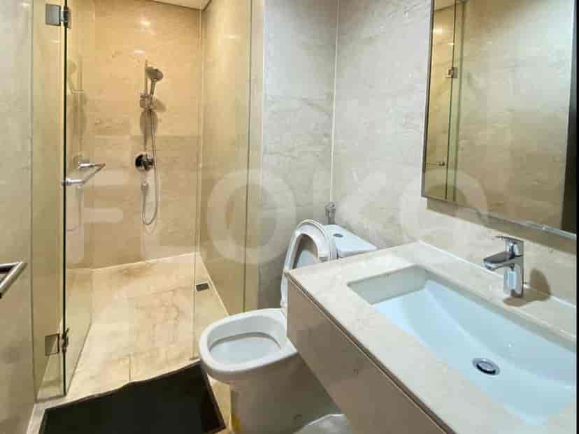 Modern bathroom with a glass shower enclosure, a toilet, and a vanity with a sink.