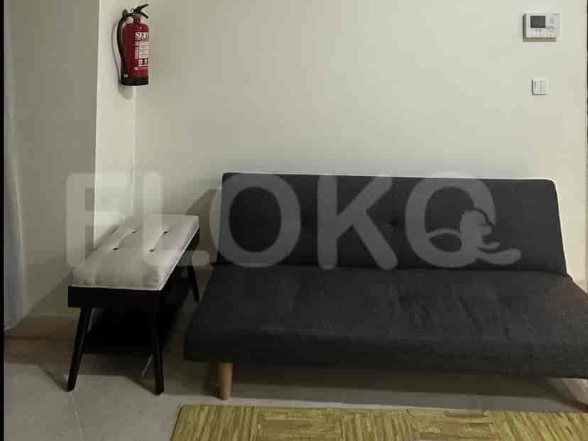 Living room with sofa, fire extinguisher, and a bench.
