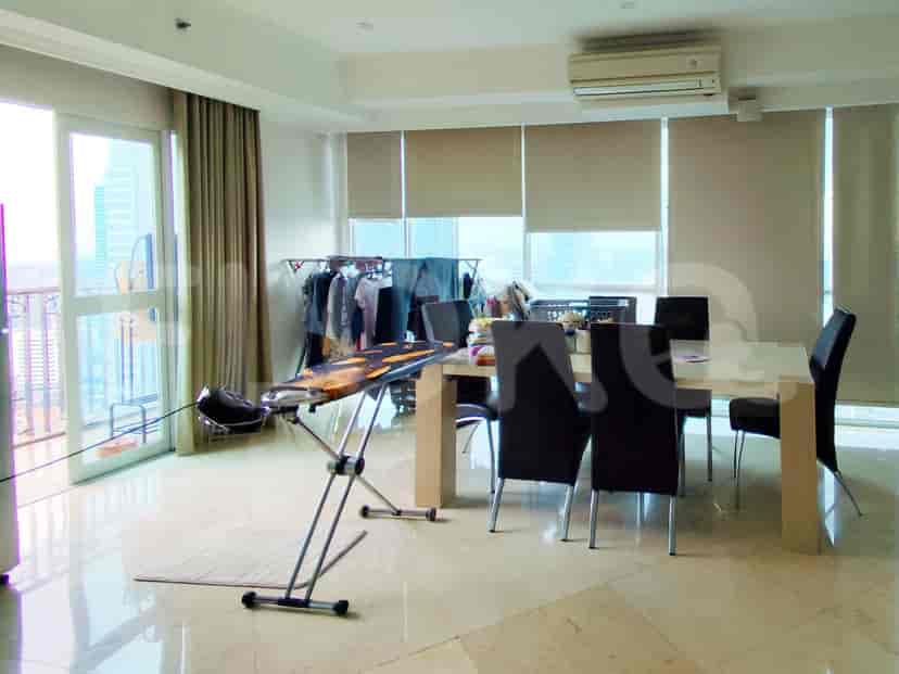 An open-plan dining area with a table, chairs, and a view of the city.