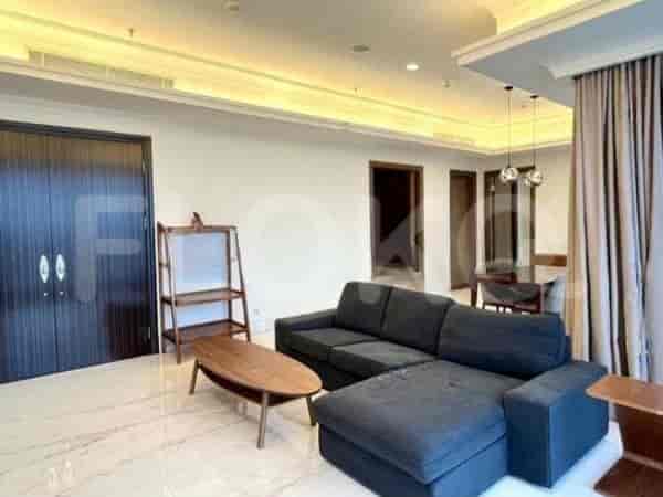 Living area showing a sectional sofa, shelving, and a dining area.