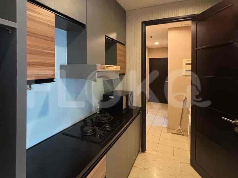 A close-up view of the kitchen with the stove, cabinets, and door to other rooms.