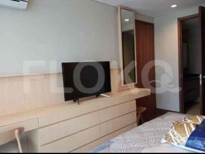 Bedroom with a bed, TV, and wooden dresser.