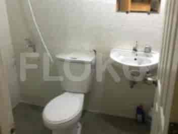 A bathroom with a toilet, a sink, and a shower area.