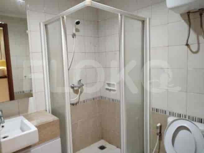 A bathroom with a glass shower, toilet, and sink.