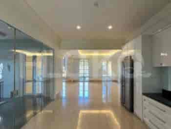 A bright living area with light wooden flooring and open kitchen, with glass walls.