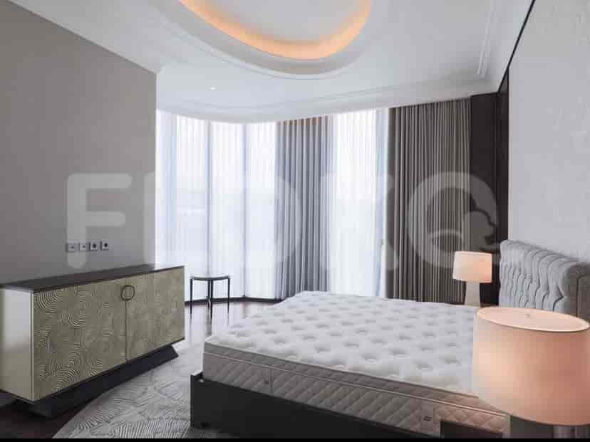 A luxurious bedroom with a large bed, a modern dresser, and views from a curved window.