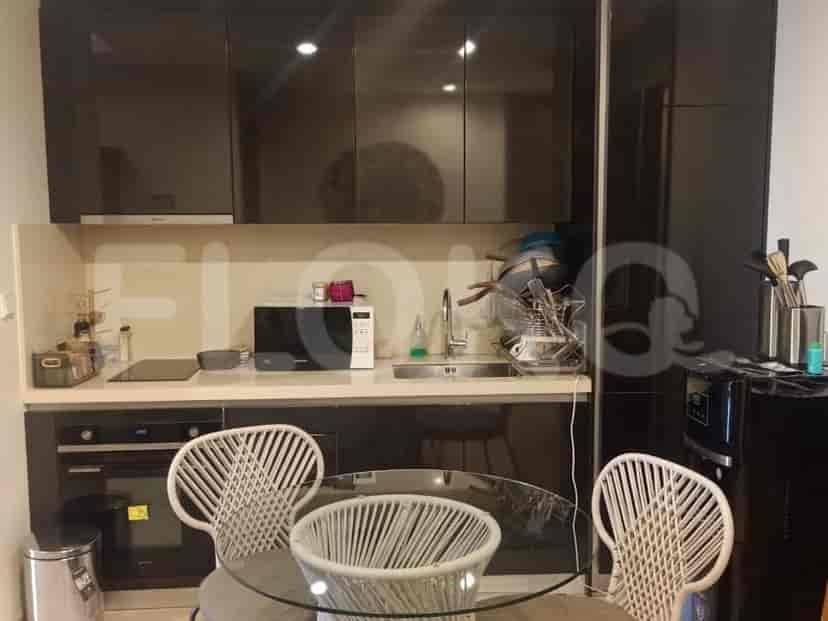 A modern kitchen with a glass table and chairs.