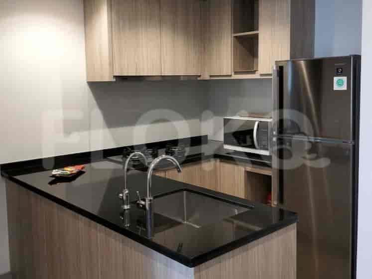 Dapur modern dengan lemari kayu, meja dapur hitam, wastafel, keran, kompor gas, dan microwave.