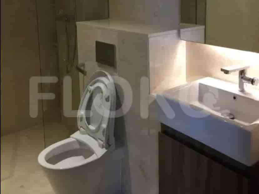 Pemandangan kamar mandi yang menampilkan toilet dan wastafel.