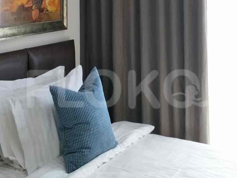 A bedroom featuring a bed with pillows and a headboard, near a curtain.