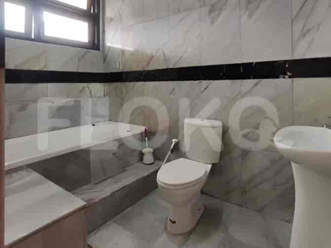 A bathroom featuring marble tile walls, a bathtub, and a Western-style toilet.