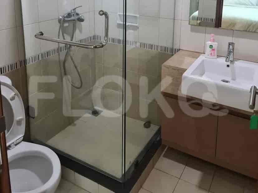 A bathroom with a toilet, a glass-enclosed shower, and a vanity with a sink.