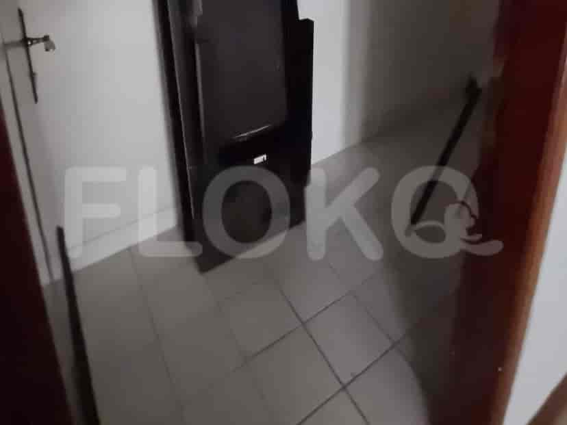 A glimpse into a bathroom doorway with tiled flooring.