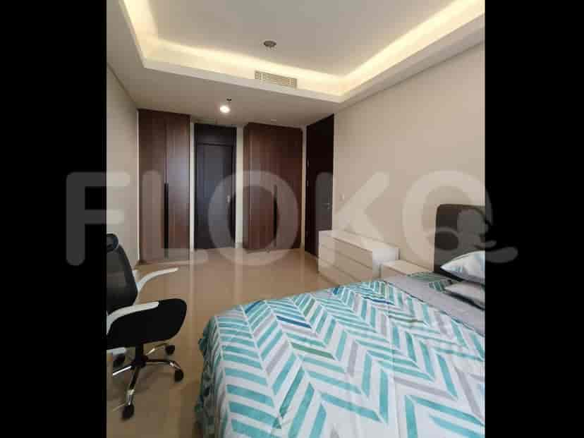 A bedroom with a king-size bed, two wooden wardrobes, and a desk chair.
