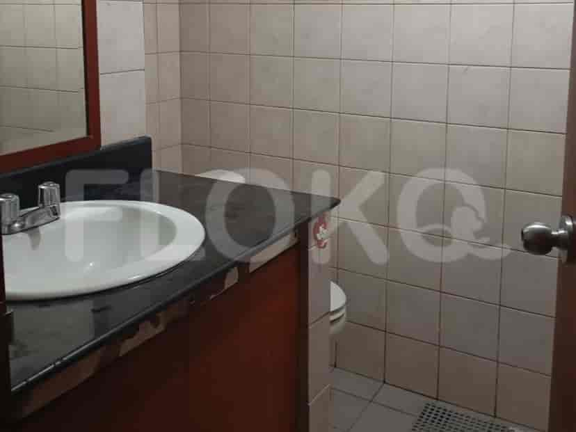 Kamar mandi dengan wastafel, meja rias, dinding berubin, dan toilet.