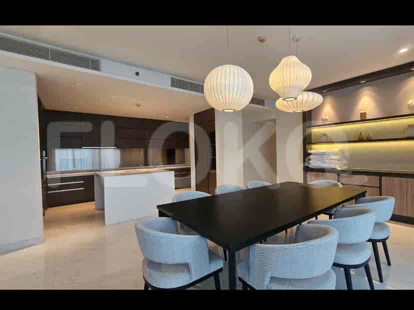 An open-plan dining area and kitchen with a large dining table and a modern kitchen island.