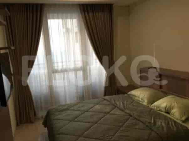 The bedroom features a bed with a wooden headboard and a large window with curtains.