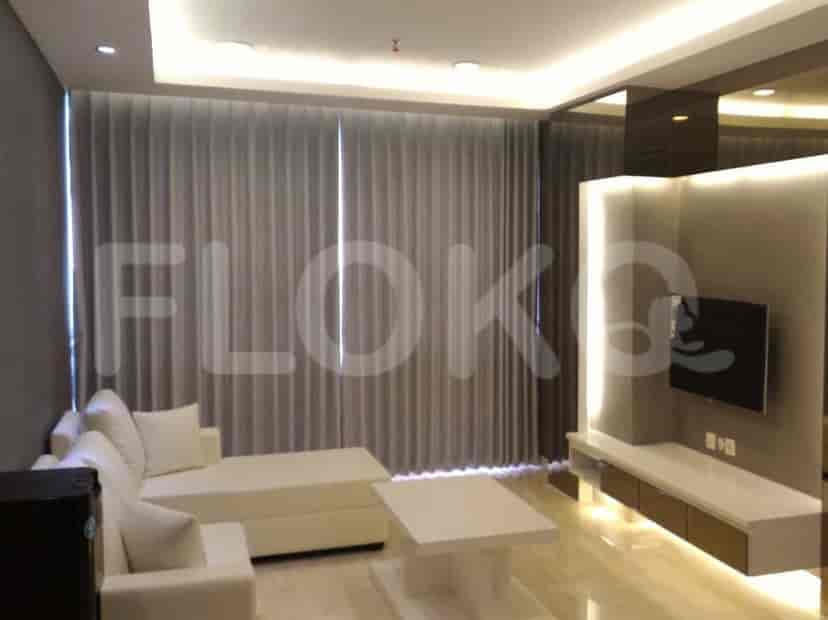 A living room with a white L-shaped sofa, a white coffee table, and sheer curtains.
