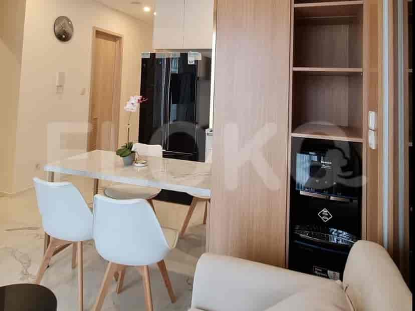 A modern bathroom with a white square sink, wooden vanity, and a glass-enclosed shower.