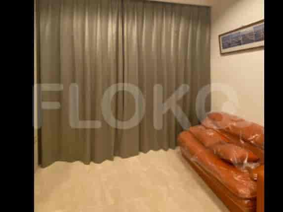 A dimly lit living room with grey curtains covering a large window and an orange sofa wrapped in plastic.