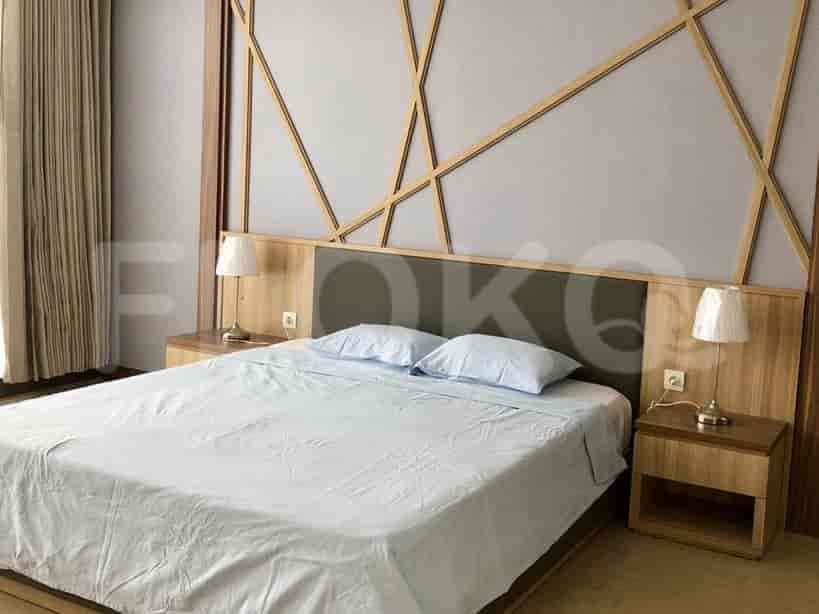 Sebuah kamar tidur dengan tempat tidur ukuran queen, meja samping tempat tidur, dan panel dinding kayu dekoratif.