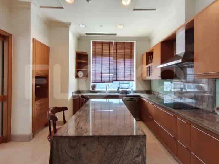 A spacious kitchen with granite countertops, wooden cabinets, and a large island.