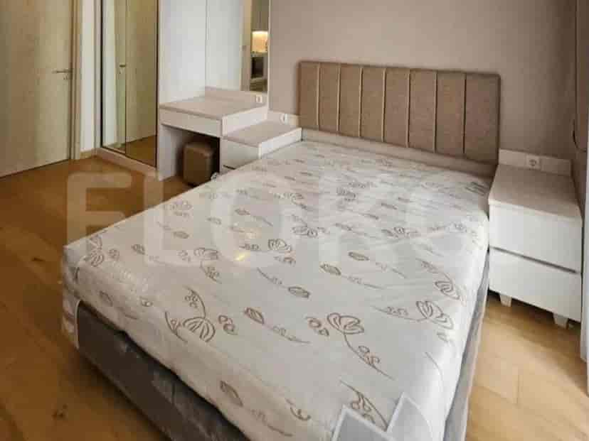 A bedroom with a queen-sized bed, a vanity desk, and a closet.