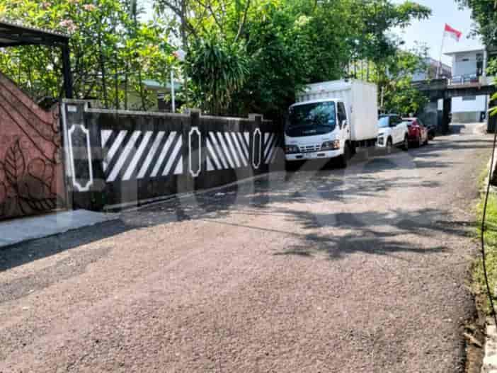 A paved driveway leads to a house with a white container truck parked nearby.
