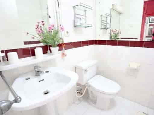 Kamar mandi dengan wastafel, toilet, dan cermin.