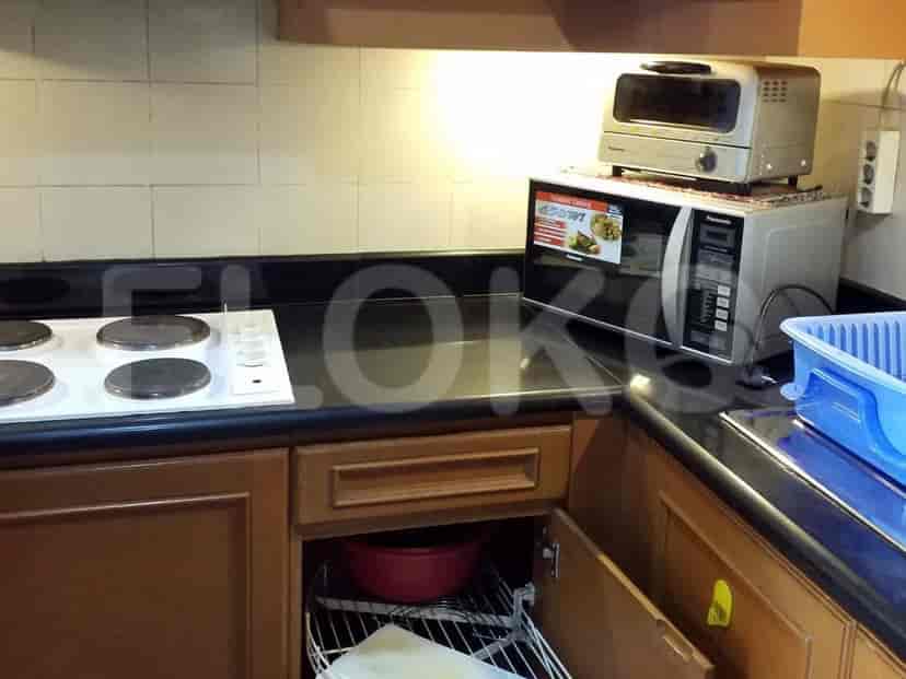 A compact kitchen with an electric stove, microwave, and toaster oven.