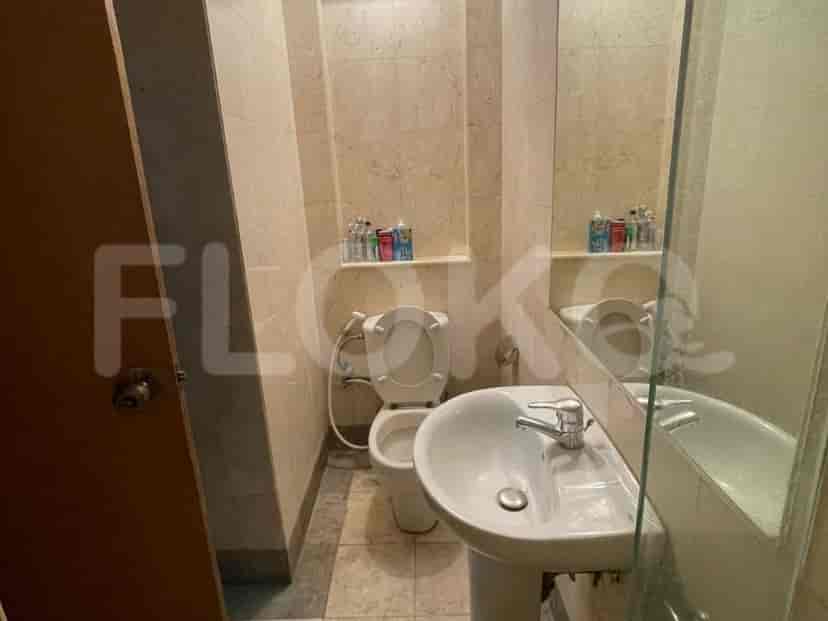 Bathroom with toilet, sink and mirror.