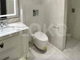 A luxurious bathroom with marble accents, featuring a modern toilet, a vanity with a marble countertop, and a walk-in shower.