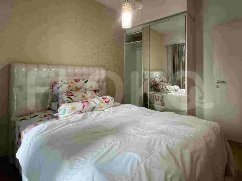 Sebuah kamar tidur dengan tempat tidur besar, nakas, dan lemari pakaian dengan pintu cermin.