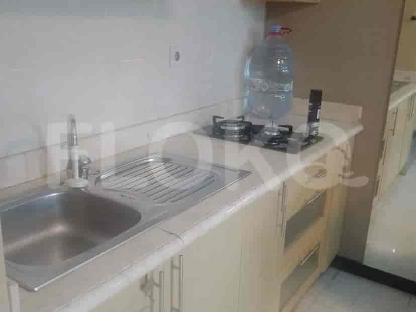 A compact kitchen area with a sink, gas stove, and cabinets.