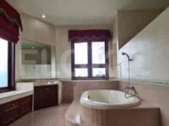 A bathroom with a bathtub, a window, and a vanity.