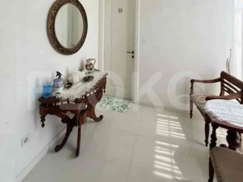 An entryway with a wooden console table, a round mirror, and wooden benches.