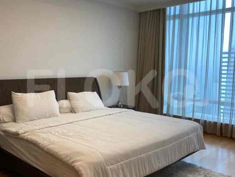 Kamar tidur utama dengan tempat tidur king-size, meja nakas, dan jendela besar dengan tirai tipis.