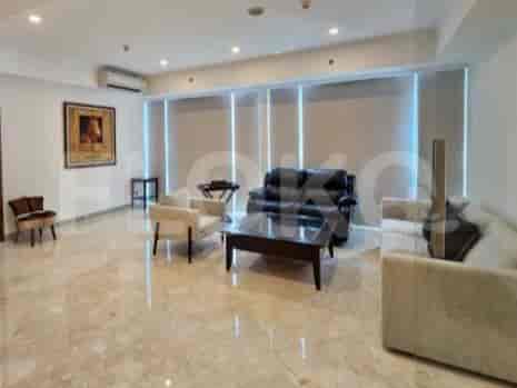 A spacious living room with a leather sofa, armchairs, and a coffee table.