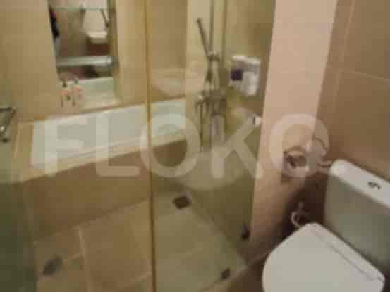 A bathroom with a bathtub, shower, toilet, and glass partition.
