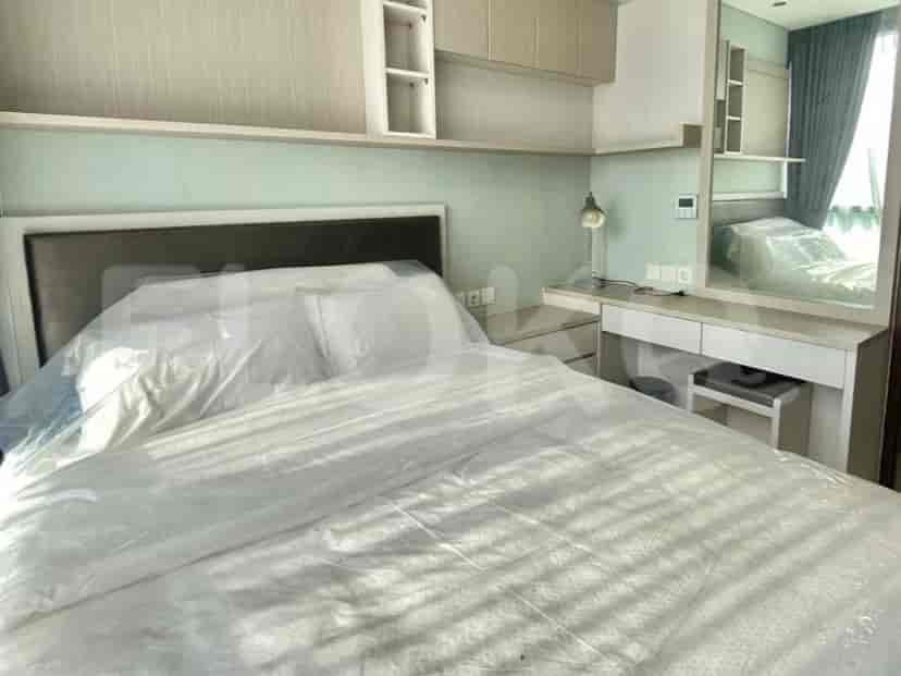 Bedroom with a queen-sized bed covered in plastic sheeting, a vanity table with a mirror, and built-in wardrobes.