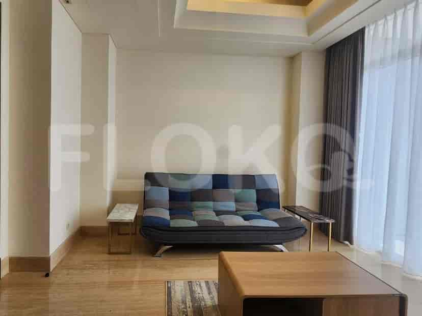 A bright living room with a multi-colored sofa, two small side tables, and a coffee table.