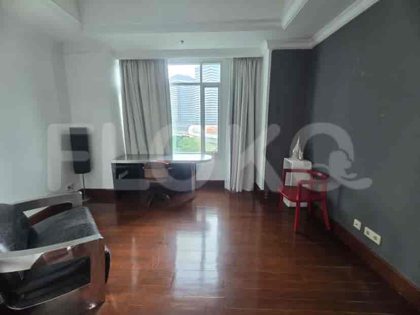 Ruang kantor rumah dengan meja, kursi, dan area duduk, dekat jendela besar.